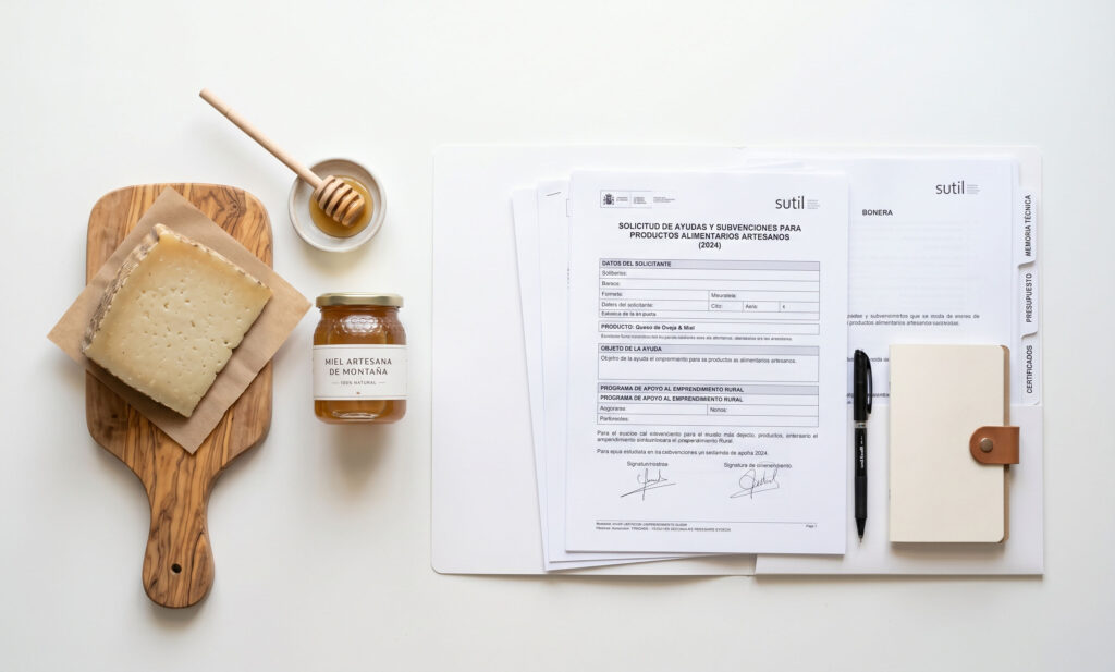 Composición cenital con producto alimentario artesano, documentación administrativa ordenada y planta viva sobre mesa de trabajo